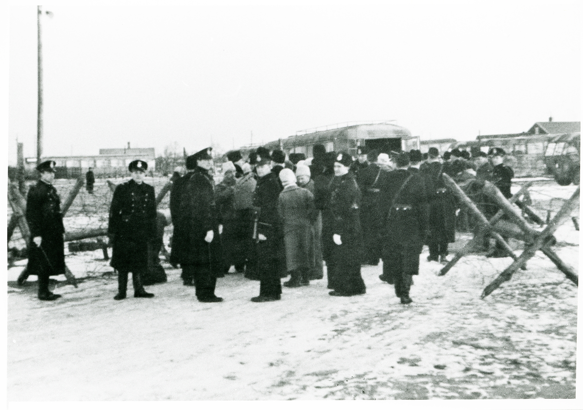 Rinkaby utanför Kristianstad. Fångläger för balter m.fl., januari 1946.
Polisvakt i väntan inför förflyttning av fångarna med buss till Trelleborg och deportation.