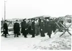 Rinkaby utanför Kristianstad. Fångläger för balter m.fl., januari 1946.
Polisvakt i väntan inför förflyttning av fångarna med buss till Trelleborg och deportation.