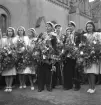 Studentfinal, 1944. 
En  grupp studenter sjunger (?) vid Esaias Tegnérs staty.
I bakgrunden syns en del av domkyrkan. 

Angående avgångsklassen 1944 - se 