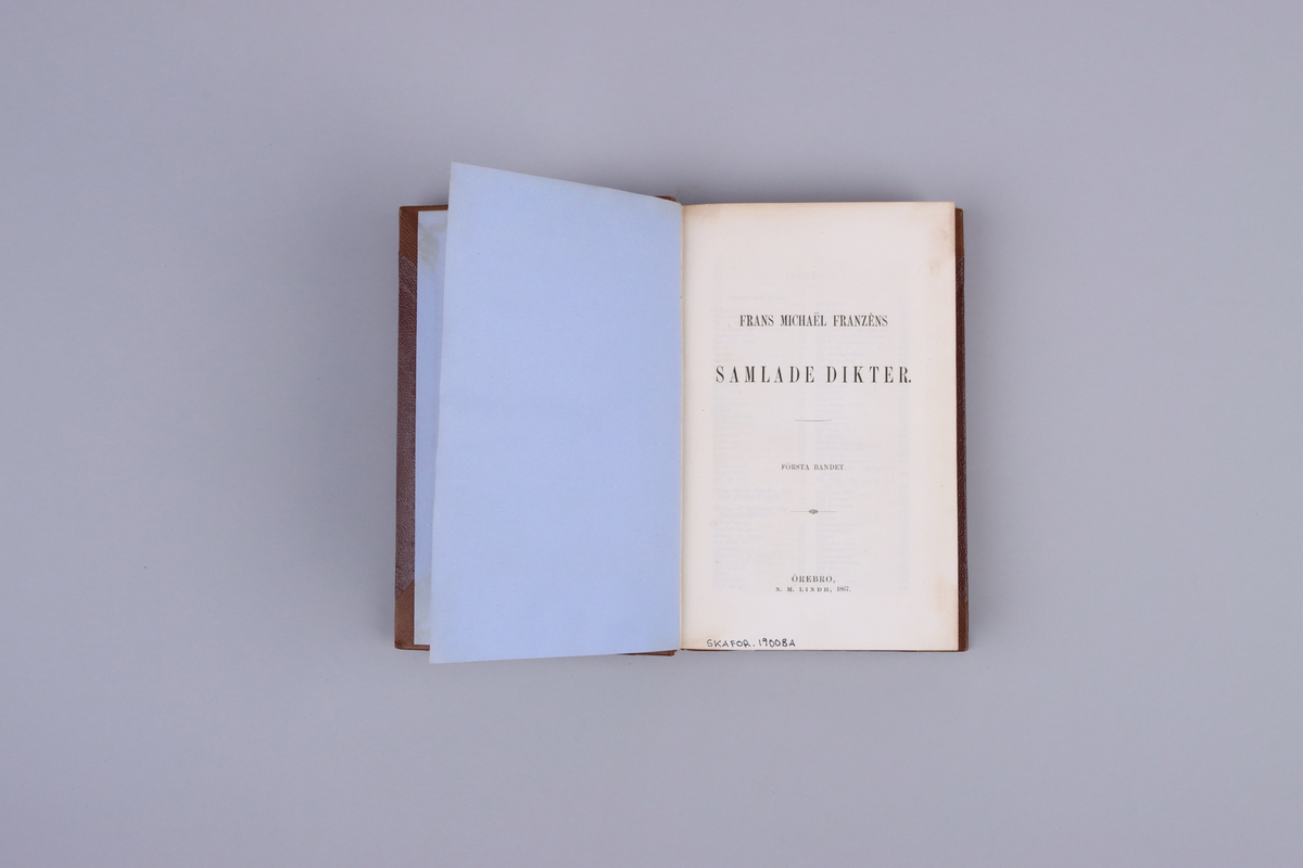 Bok, del av bokband på fyra delar. Ljusbrunt pappersband med mönsterpressad  och guldorerad rygg med upphöjda bind. Brunt pärmpapper och ljusbruna snitt. Titelsida med "Frans Michaël Franzéns samlade dikter. Första bandet".