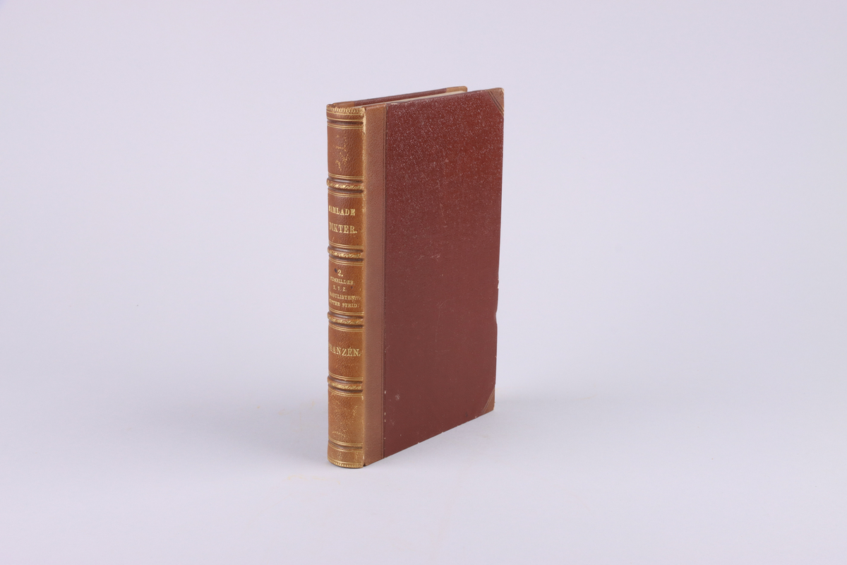 Bok, del av bokband på fyra delar. Ljusbrunt pappersband med mönsterpressad  och guldorerad rygg med upphöjda bind. Brunt pärmpapper och ljusbruna snitt. Titelsida med "Frans Michaël Franzéns samlade dikter.  Andra bandet".