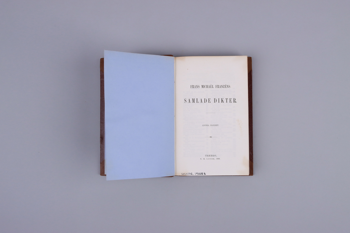 Bok, del av bokband på fyra delar. Ljusbrunt pappersband med mönsterpressad  och guldorerad rygg med upphöjda bind. Brunt pärmpapper och ljusbruna snitt. Titelsida med "Frans Michaël Franzéns samlade dikter.  Andra bandet".