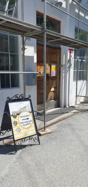 skilt som viser mot inngangsdør til museet