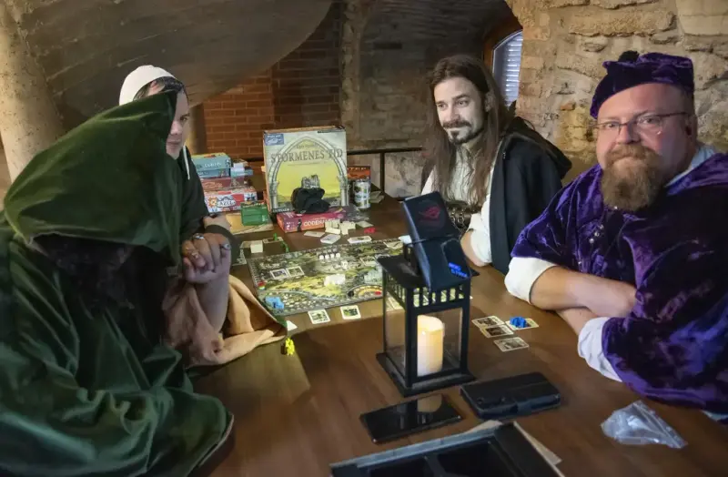 Spillere i middelalderklær som spiller historiske brettspill