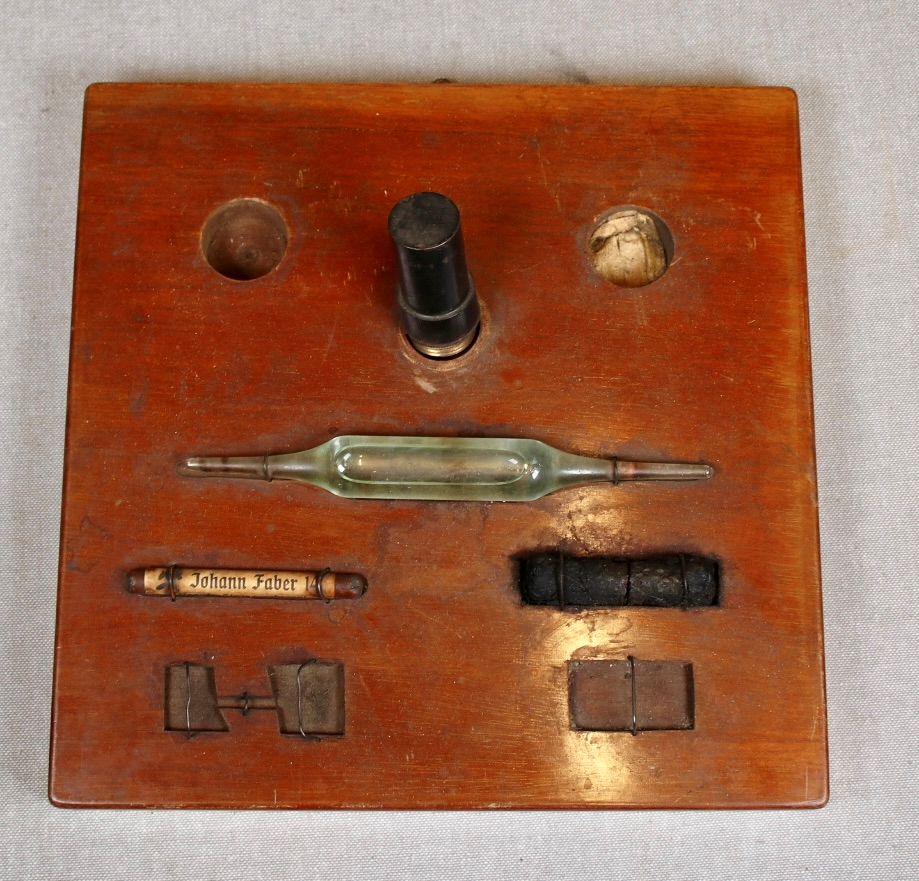 Låsbar rektangulær lysbrun koffert med metallbeslag på sidene, og trebeslag forsterket med messing. Kofferten er merket med romertall III på lokket. Hemper i lær som håndtak på hver kortside. To låser i messing. Hovedmaterialet er trolig tre. Kofferten er kledt med tekstil innvendig, og oljelerret (?) på utsiden. Enkel dekormaling