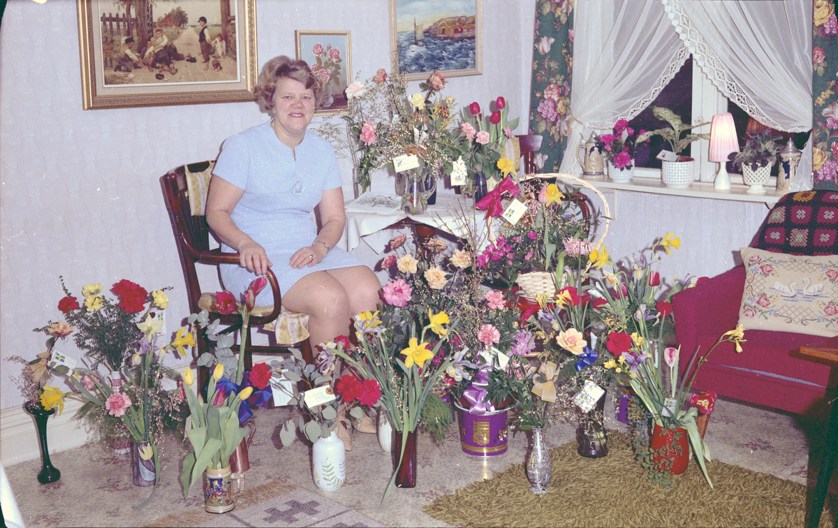 Gunborg Svensson Lindberg fotograferad omgiven av blommor i samband med sin 50 årsdag.