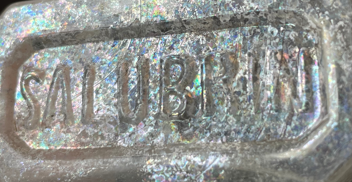 Flaskbotten med text "SALUBRIN" i relief i botten.