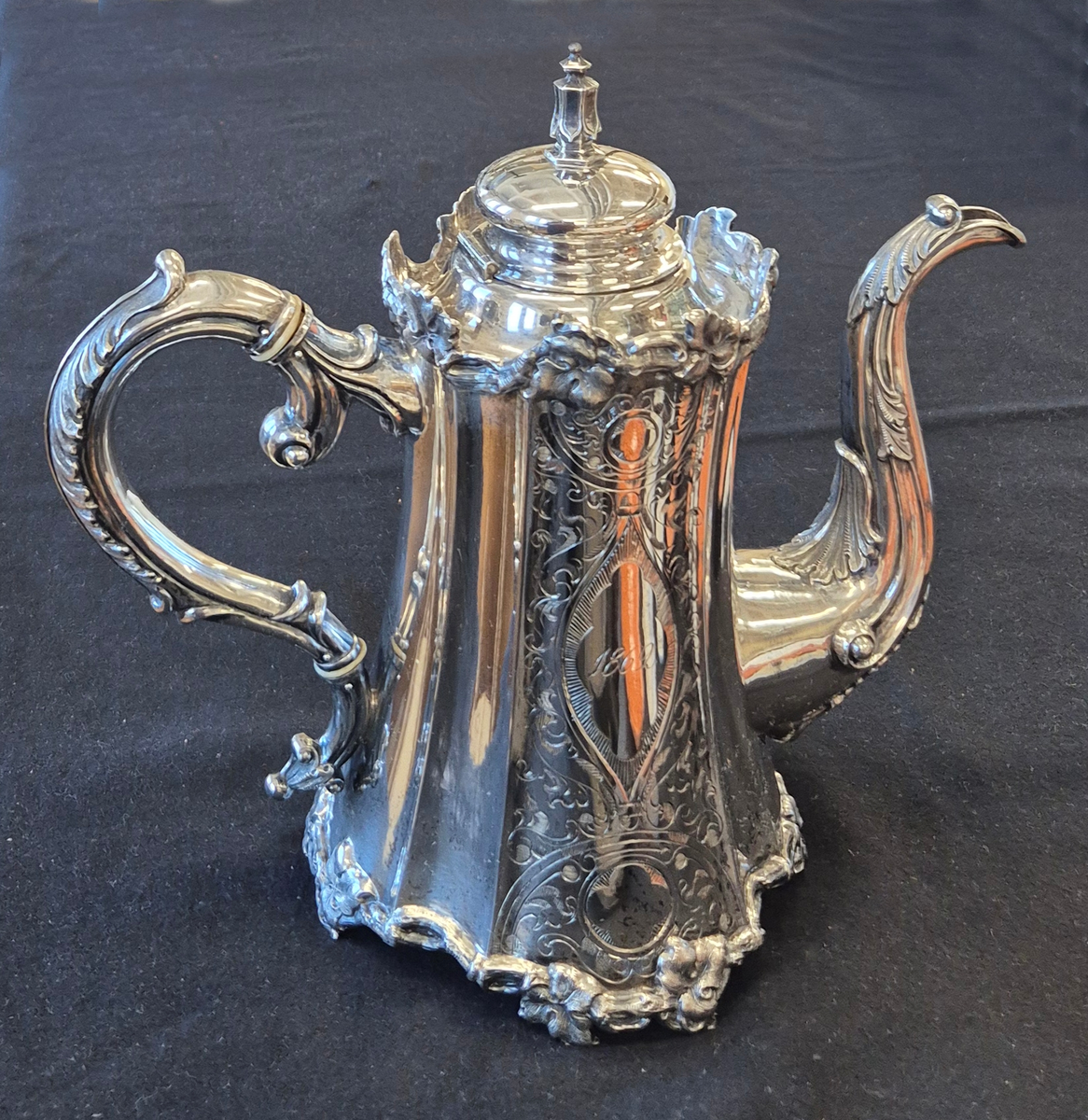 Kaffekanna i silver. Götisk modell. Pressat hantag och pip. Lock med knopp och fäst mot kannan med gångjärn. Initialerna till Oscar Geijer och Fredrique Unger finns graverade på ena sidan av kannan. På andra sidan är ingraverat 1862, året då de gifte sig.