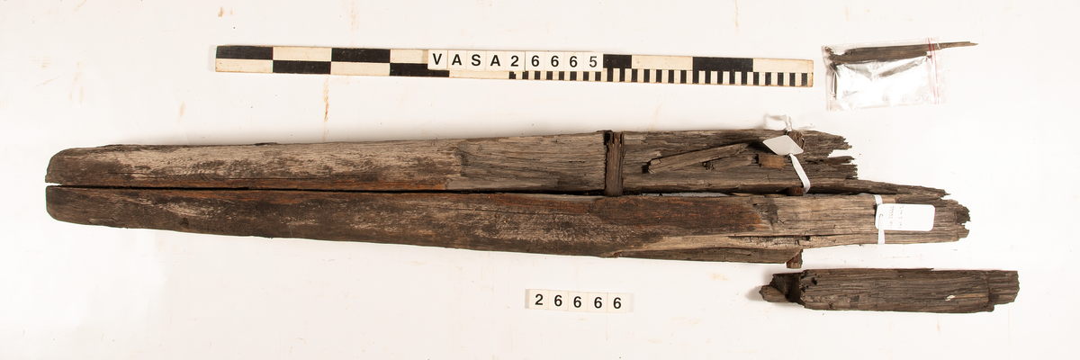 Ankarstock som ursprungligen består av två sammanfogade delar. Den sammanfogade stocken har sedan spruckit tvärsöver i två delar.  Ena halvan av en ankarstock sammanfogad med den andra halvan med 12 dymlingar.