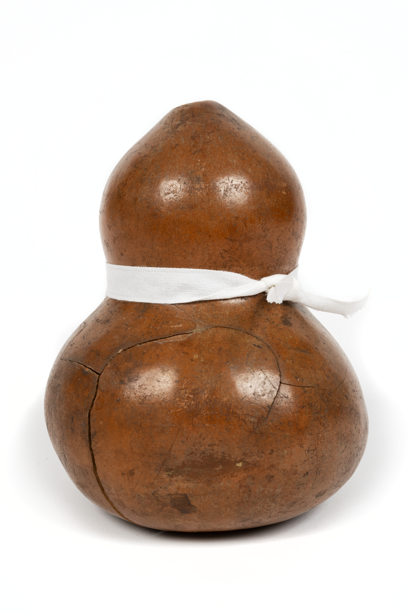 Kärl gjort av en tuktad, torkad gurka från Japan. Päronformat med stark insvängning i mitten. Litet hål upptill. Från fregatten Vanadis världsomsegling 1883-1885.
