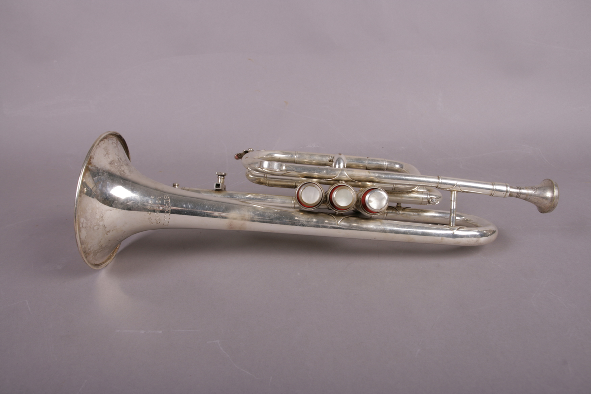 Blåseinstrument i metall med klaffer og ventiler.