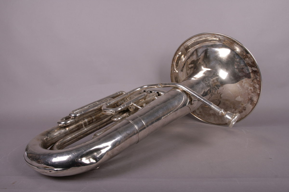 Blåseinstrument i metall med klaffer og ventiler.