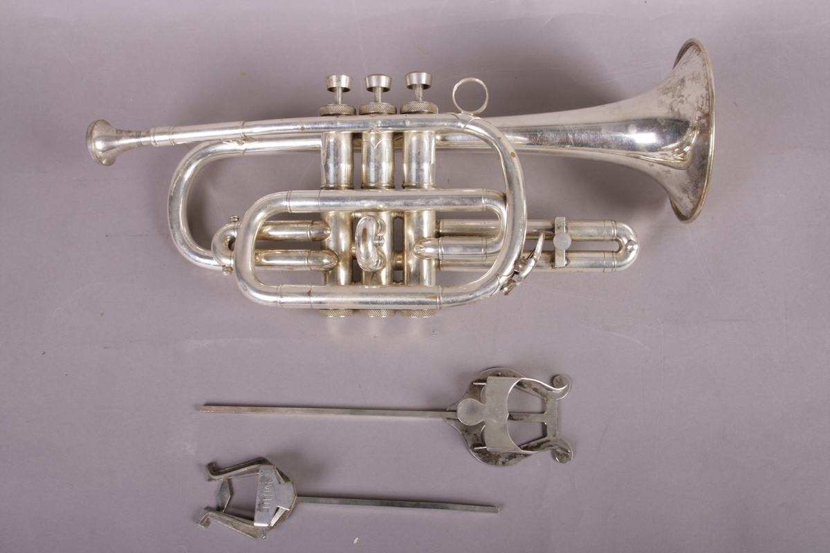 Blåseinstrument i metall med klaffer og ventiler.