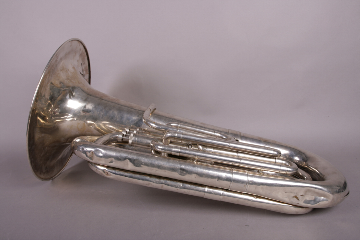 Blåseinstrument i metall med klaffer og ventiler.