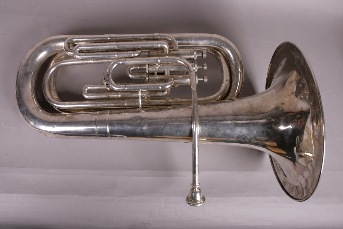 Blåseinstrument i metall med klaffer og ventiler.