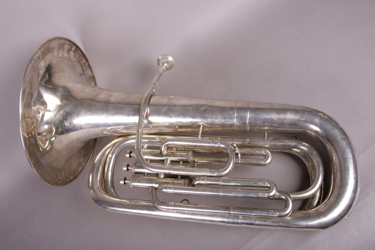 Blåseinstrument i metall med klaffer og ventiler.