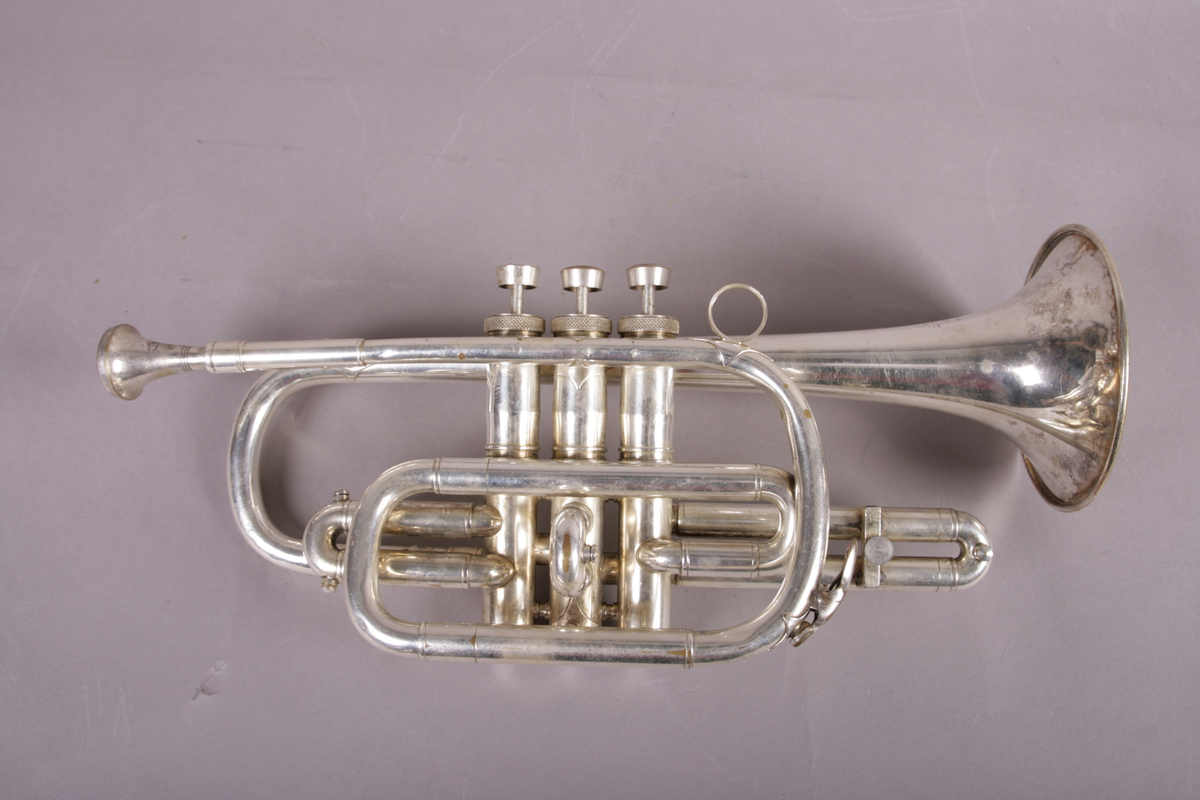 Blåseinstrument i metall med klaffer og ventiler.