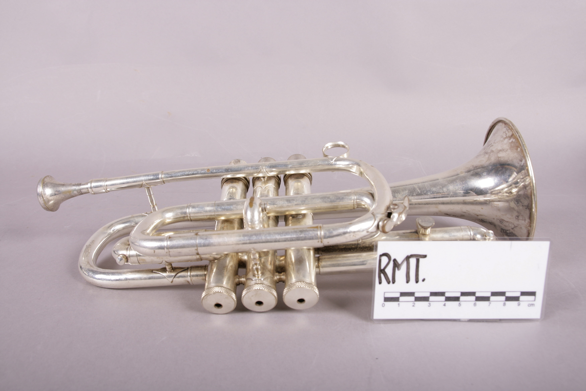 Blåseinstrument i metall med klaffer og ventiler.