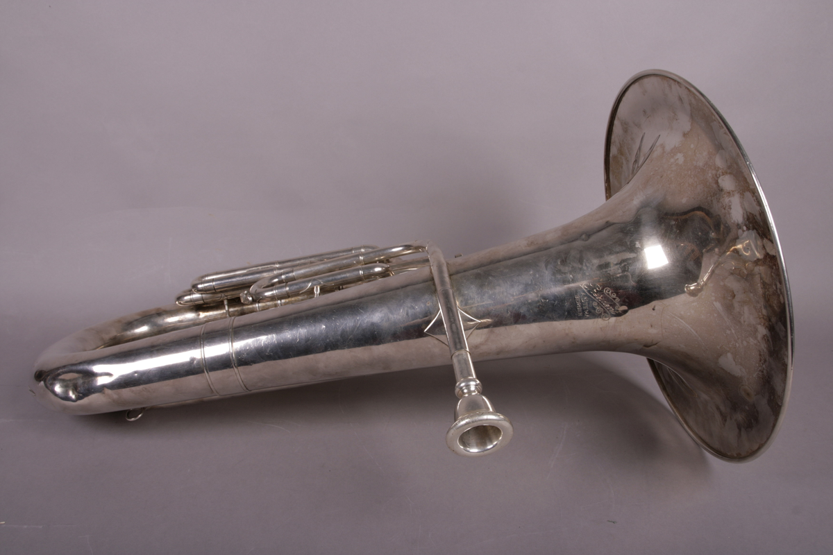 Blåseinstrument i metall med klaffer og ventiler.
