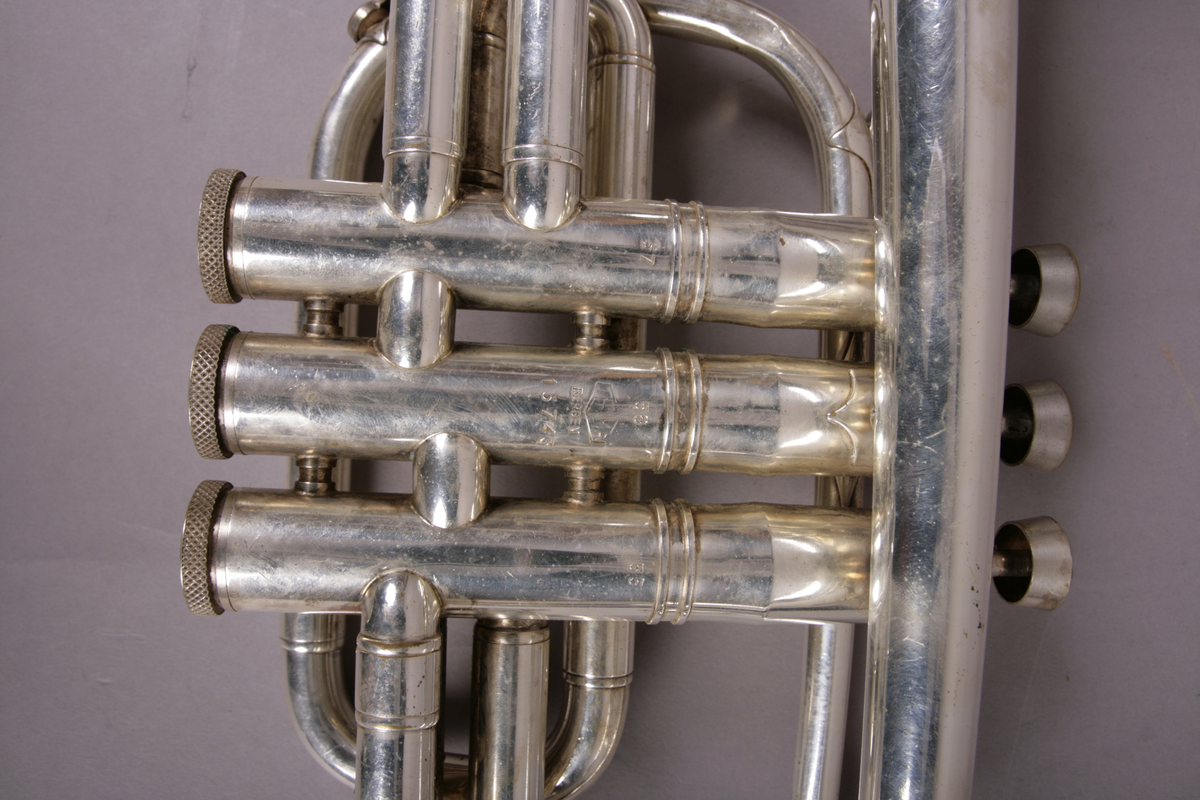Blåseinstrument i metall med klaffer og ventiler.