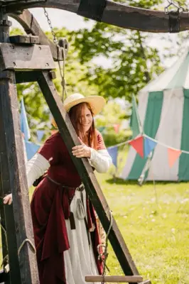 Kvinne i rød middelalderdrakt ved karusell