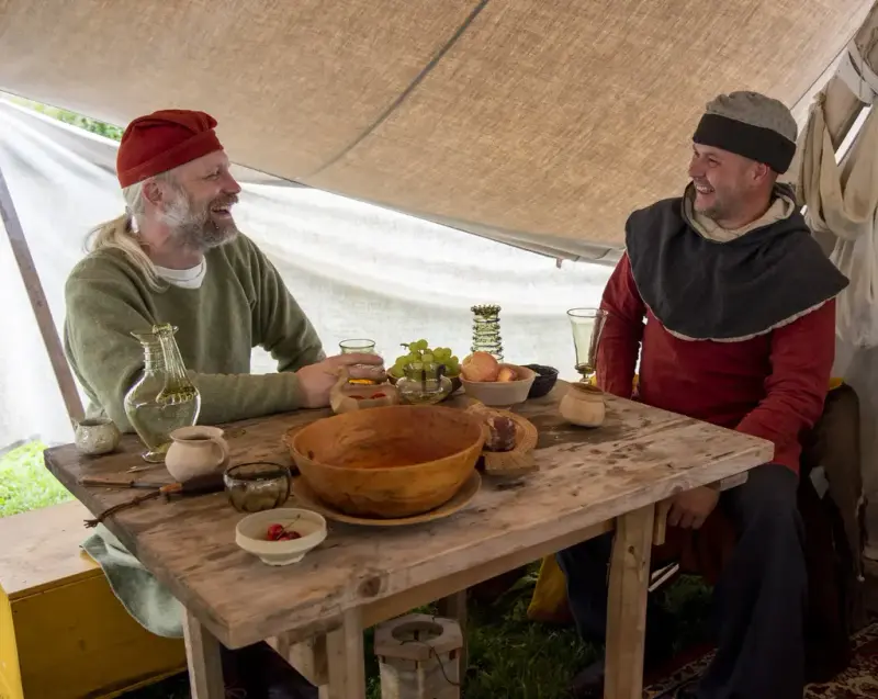 To menn i middelalderklær ved et bord