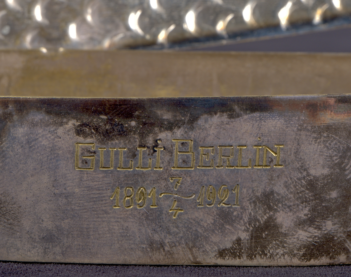 Skrin av nysilver, utformat som en havsfisk – sannolikt en lax. Skrinet är detaljrikt utfört med graverade fjäll, fenor och stjärt, och öppnas längs långsidan. På framsidan finns en graverad inskription: "Gulli Berlin 1891 7/4 – 1921".  På undersidan finns stämplar: "JV. PRIMA NS. W". Skrinet öppnats längs långsidan.

Inuti skrinet återfinns ett litet fiskenät av bomull samt 31 pappersark, alla utskurna i samma fiskform som skrinet. Arken är handdekorerade med teckningar och bär en handskriven berättande text, som löper kronologiskt från första till sista ark. Samtliga ark, utöver två stycken, är numrerade.