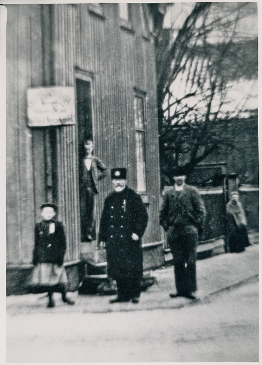 Korsningen Storgatan/Bäckgatan, ca 1900.
Till vänster syns en poliskonstapel i vinteruniform, vid ingången till vad som senare kom att kallas "Cigarr-Olles". 
I bakgrunden skymtar man fängelset,