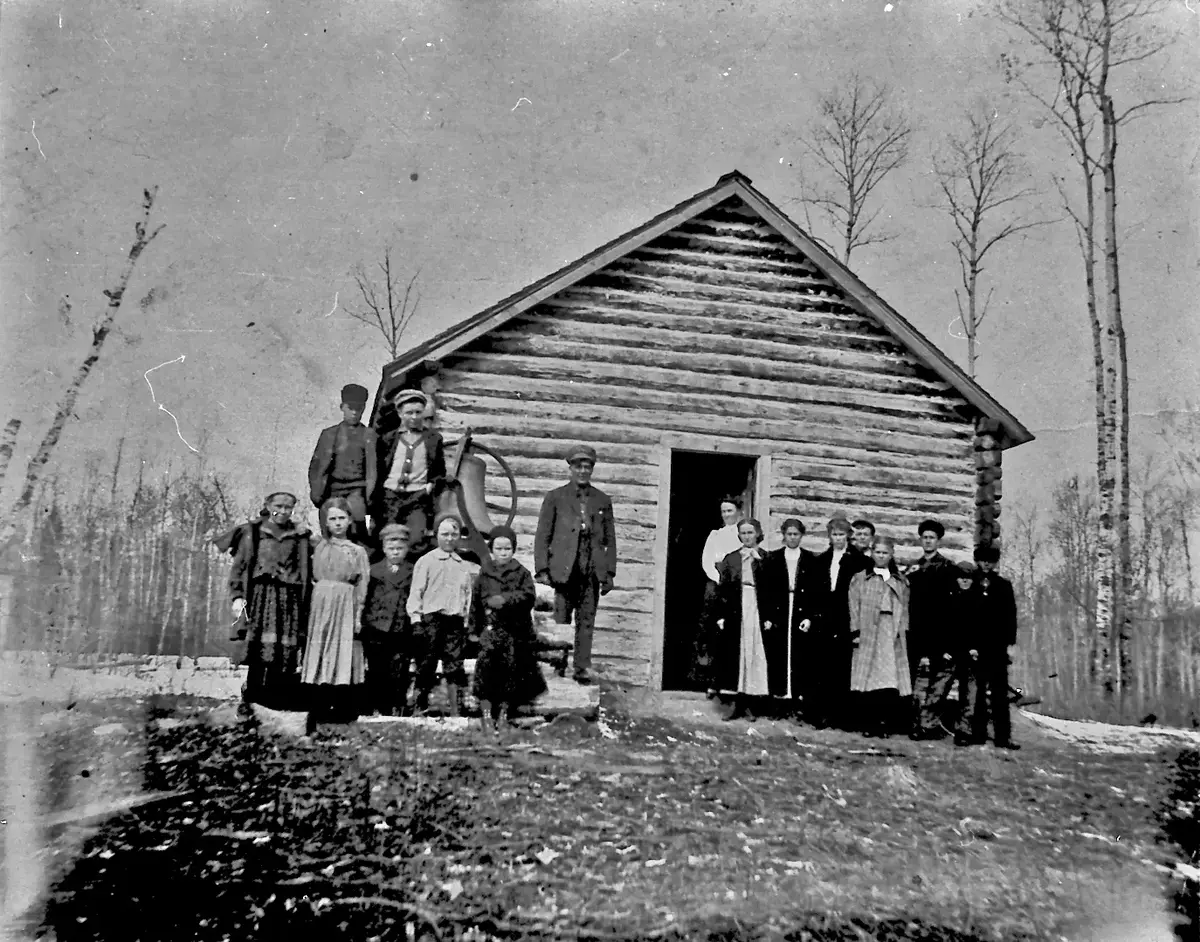Folk foran tømmerhus AMerika