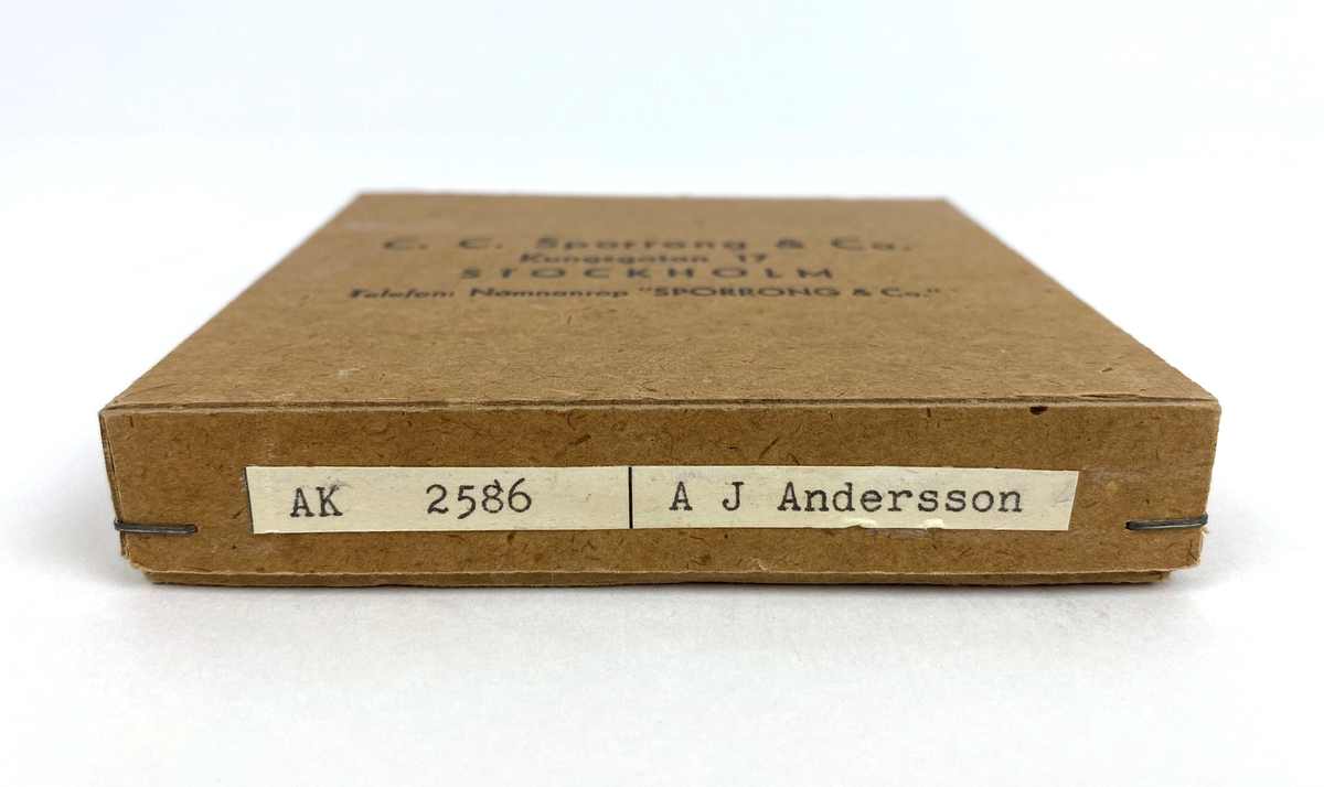 Ask i kartong tillhörande den Thulinmedalj i silver som gavs till A. J. Andersson år 1948. Ofärgad, oblekt kartong med häftade hörn. Tillverkarnamn och adress på locket.