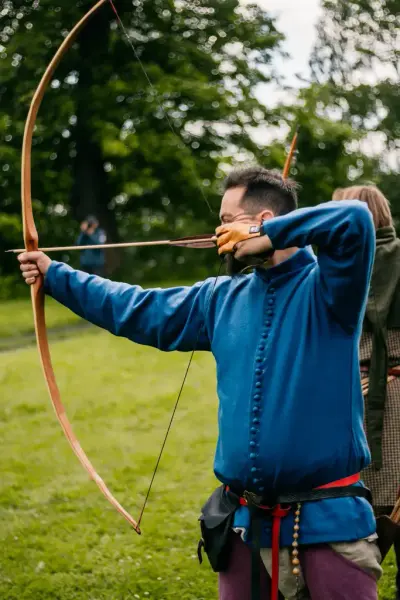Bueskytter 1300-tall med blå cotehardie og lilla hoser