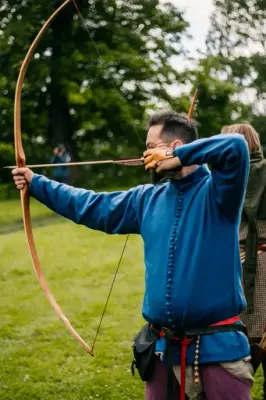 Bueskytter 1300-tall med blå cotehardie og lilla hoser