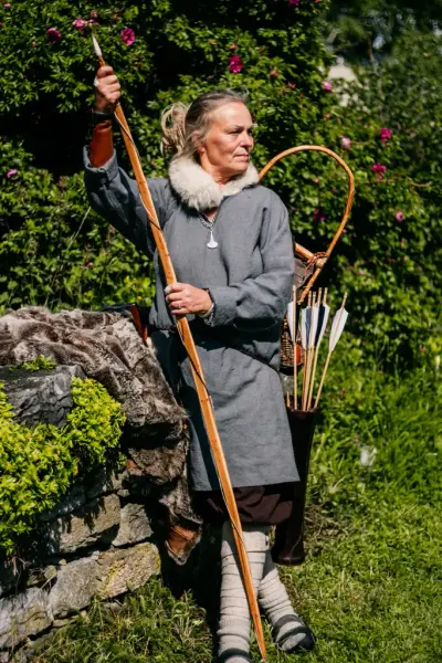 Kvinne i middelalderdrakt med langbue