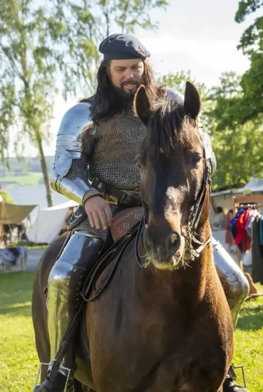 Mann i platerustning til hest