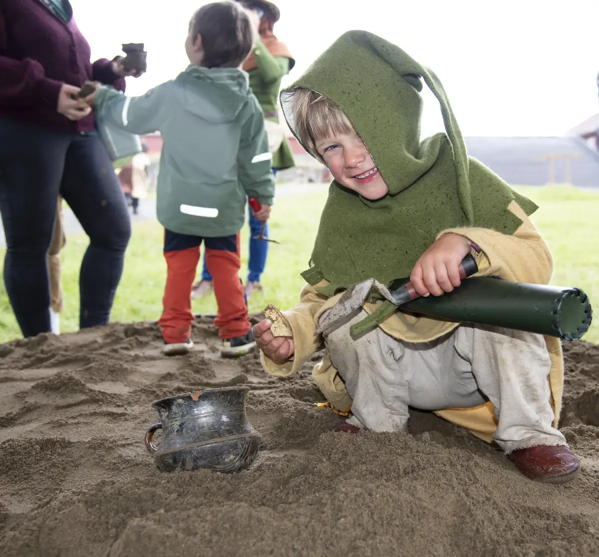 Gutt i middelalderklær som graver fram arkeologiske gjenstander