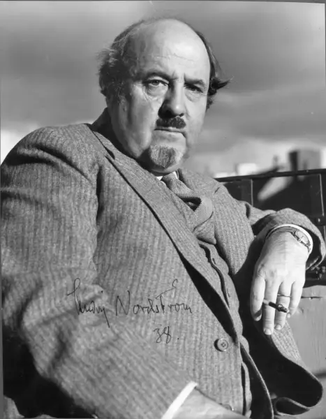 Man med cigarr i handen i svartvit foto.