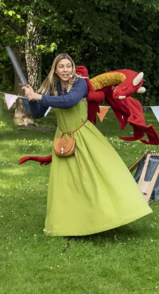 Kvinne i grønn vikingkjole som sloss med en rød drage