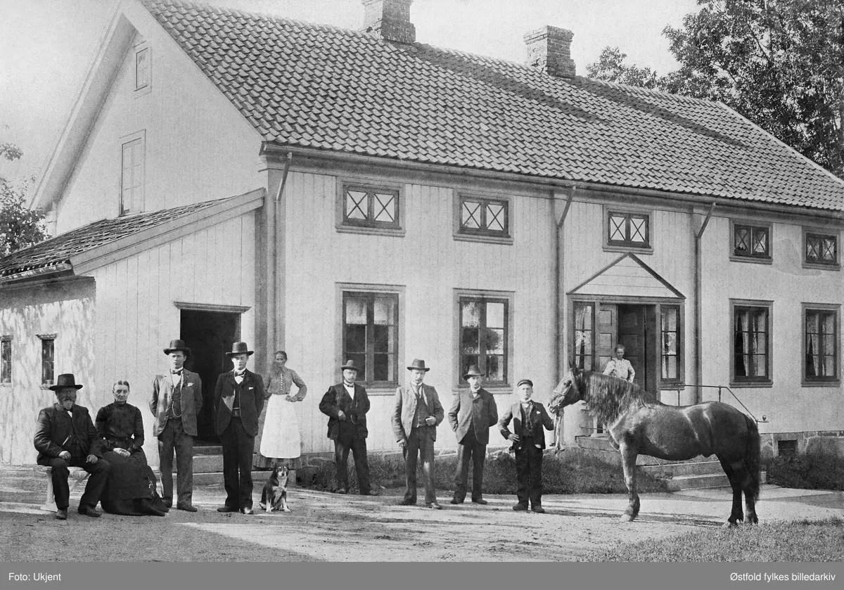 Østre Rud gård i Eidsberg ca.1905,
Fra venstre: Johan Kristian Rud, Maren Helene Rud f. Lund, Sletner, Ludvig Rud, Kristian Rud og hans hund 'Finn', Inger Sofie Lund, NN, Gunerius Rud, Johannes Rud f. 1875 stallgutten med hingsten 'Skjåk-Balder', i døra Karen.
I folketellingen 1900 er Karin Karlson, f. 1875 i Sverige, som kokkepike på Rud. Det kan være "Karen" på fotoet. Hun var der ikke ved folketellingen 1910.