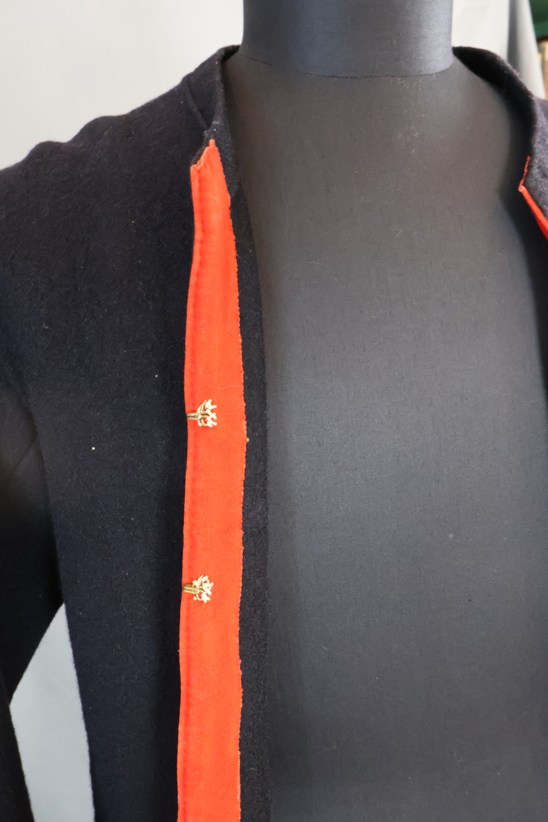 Blåtröja från Rättvik.

Blåtröjan är sydd av svart vadmal med kantning av rött kläde vid krage, framkant och ärmslut. Plagget helt ofodrat. Skörtet är skarvat. Tröjan har tre stycken hyskor på vänster sida och två stycken hakar på höger sida. Skörtet är skarvat. Sydd med en blandning av hand- och maskinsömnad.