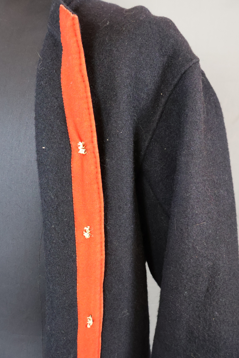 Blåtröja från Rättvik.

Blåtröjan är sydd av svart vadmal med kantning av rött kläde vid krage, framkant och ärmslut. Plagget helt ofodrat. Skörtet är skarvat. Tröjan har tre stycken hyskor på vänster sida och två stycken hakar på höger sida. Skörtet är skarvat. Sydd med en blandning av hand- och maskinsömnad.