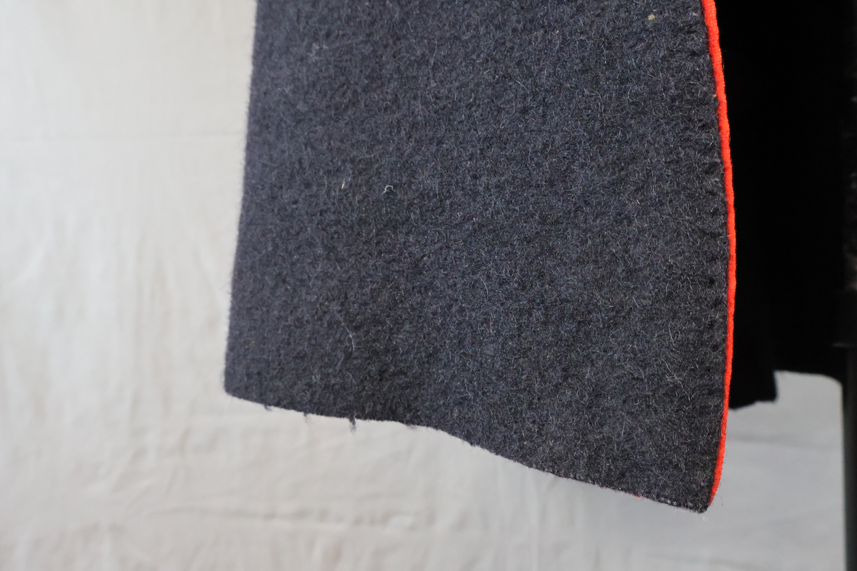 Blåtröja från Rättvik.

Blåtröjan är sydd av svart vadmal med kantning av rött kläde vid krage, framkant och ärmslut. Plagget helt ofodrat. Skörtet är skarvat. Tröjan har tre stycken hyskor på vänster sida och två stycken hakar på höger sida. Skörtet är skarvat. Sydd med en blandning av hand- och maskinsömnad.