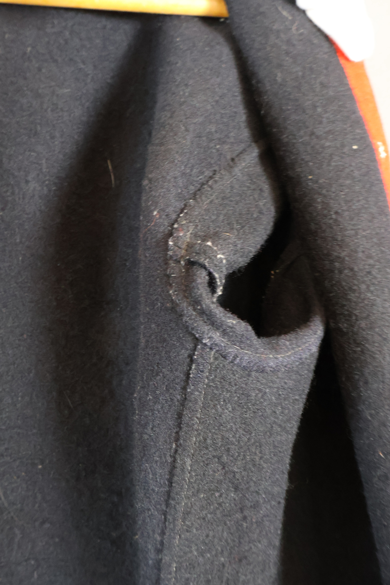 Blåtröja från Rättvik.

Blåtröjan är sydd av svart vadmal med kantning av rött kläde vid krage, framkant och ärmslut. Plagget helt ofodrat. Skörtet är skarvat. Tröjan har tre stycken hyskor på vänster sida och två stycken hakar på höger sida. Skörtet är skarvat. Sydd med en blandning av hand- och maskinsömnad.