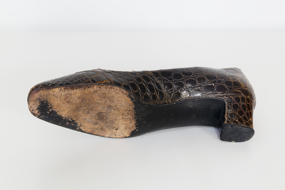 Pumps i brunt reptilskin. Storlek 3 1/2. På skons insida finns texten "Especially made for SIGMA sko Västerås". 