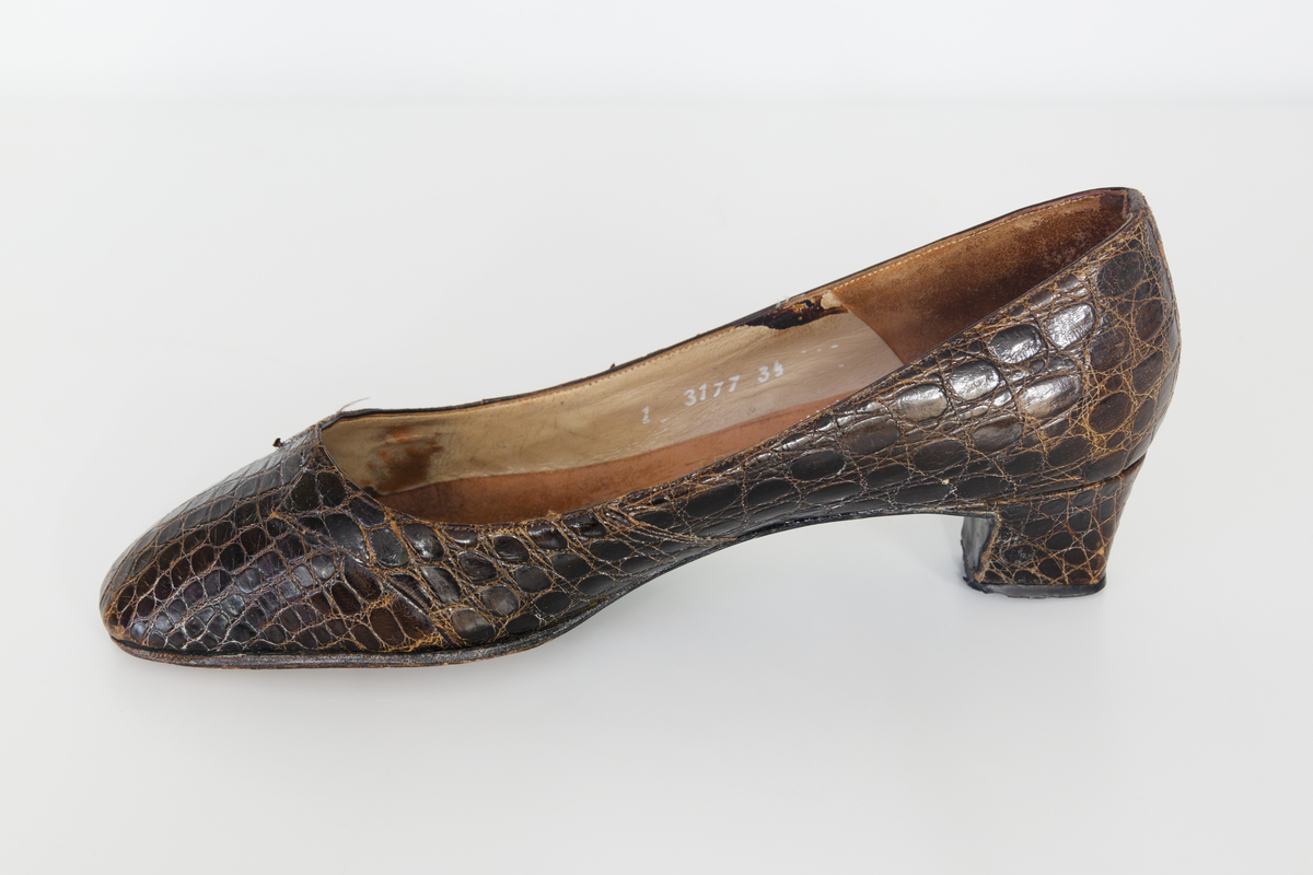 Pumps i brunt reptilskin. Storlek 3 1/2. På skons insida finns texten "Especially made for SIGMA sko Västerås". 