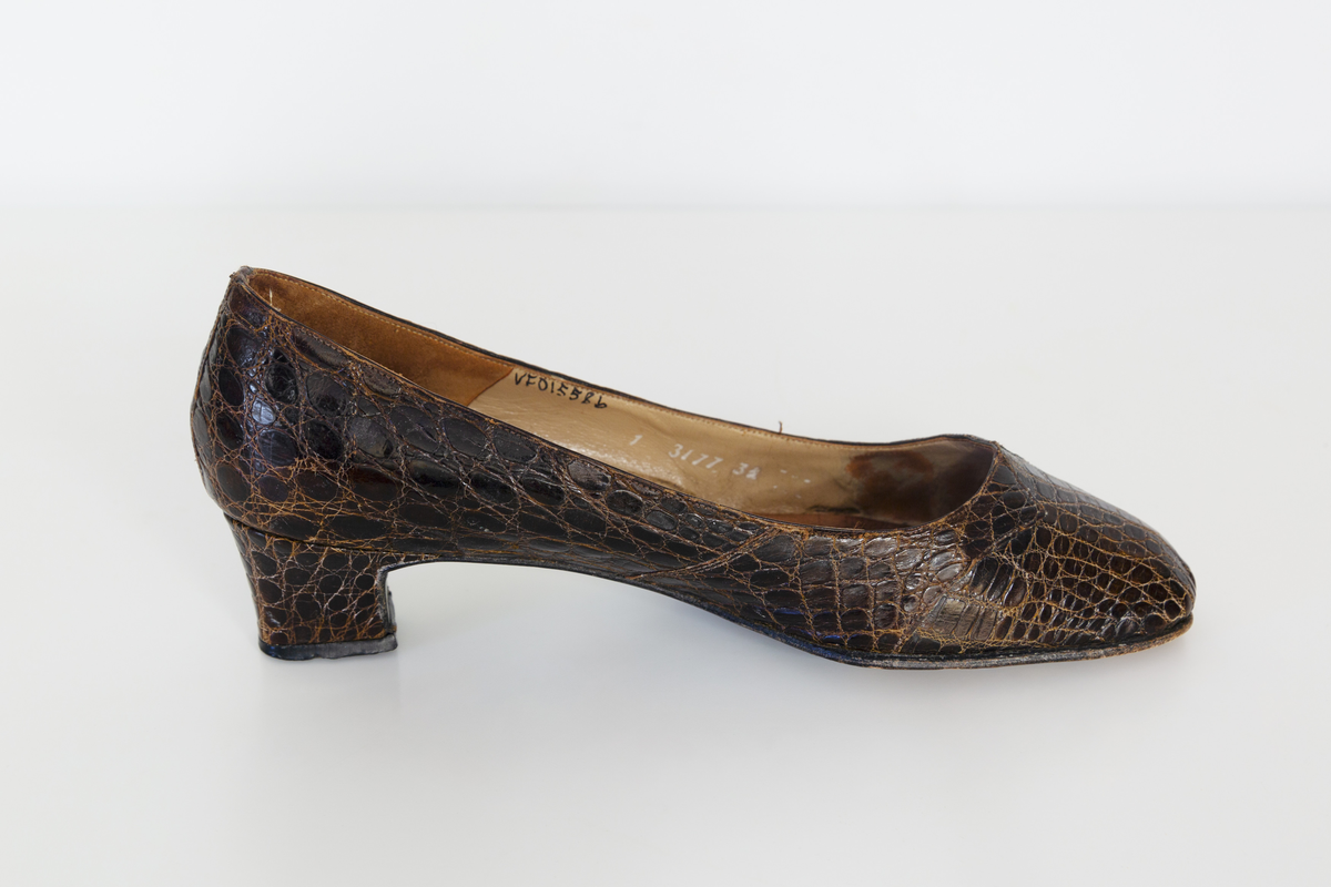 Pumps i brunt reptilskin. Storlek 3 1/2. På skons insida finns texten "Especially made for SIGMA sko Västerås". 