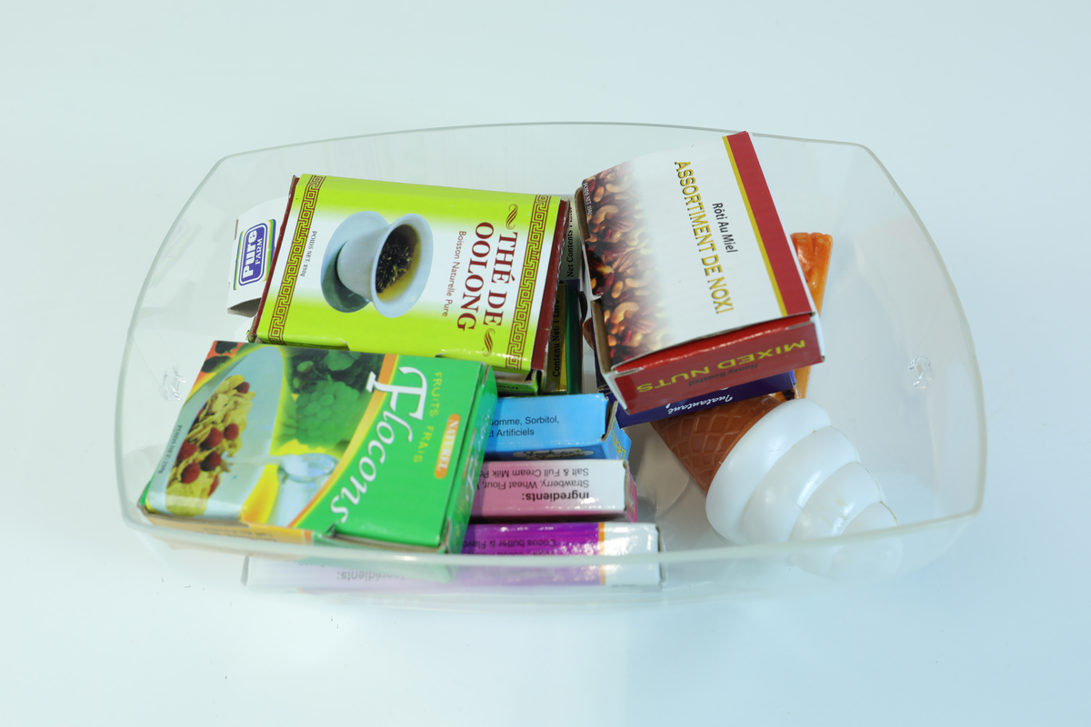 Lekemat og embalasje til barnelek i små størrelser. Det medfølger en gjennomsiktig plastboks uten lokk til å ha lekematen/embalasjen oppi.