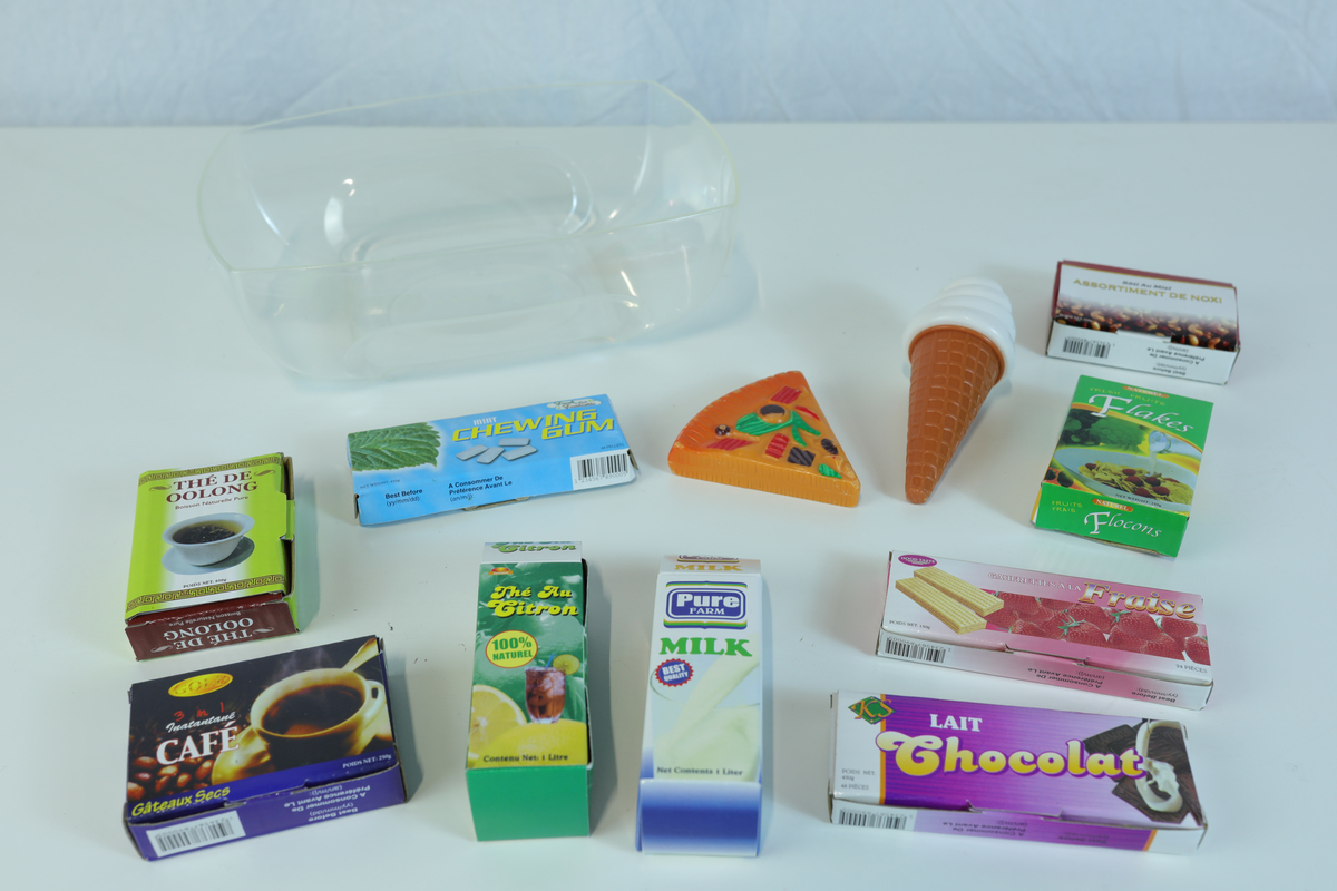 Lekemat og embalasje til barnelek i små størrelser. Det medfølger en gjennomsiktig plastboks uten lokk til å ha lekematen/embalasjen oppi.