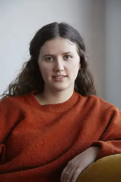 Svanhild Amdal Telnes i raud genser sitjande i ein gul stol