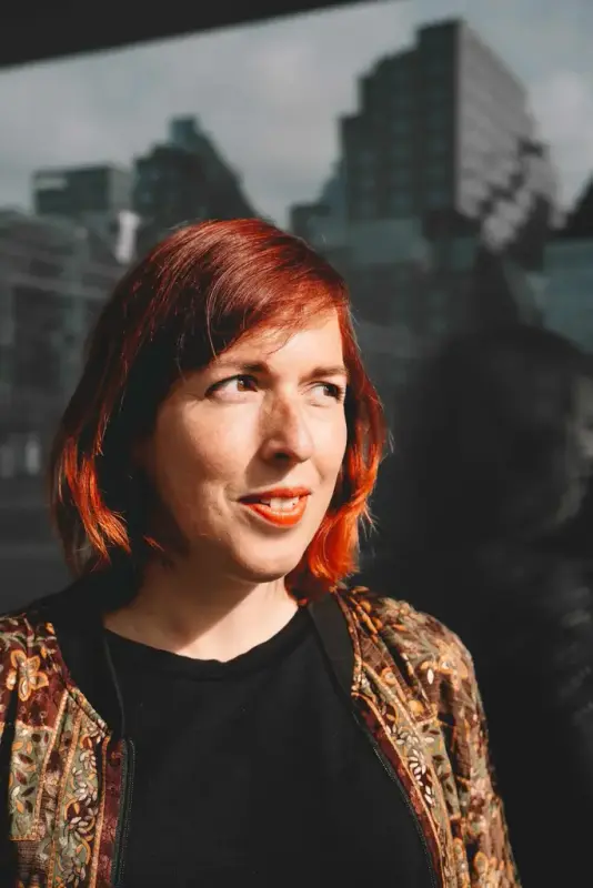 Carline Tromp ute i solskin med skyskraparar i bakgrunnen