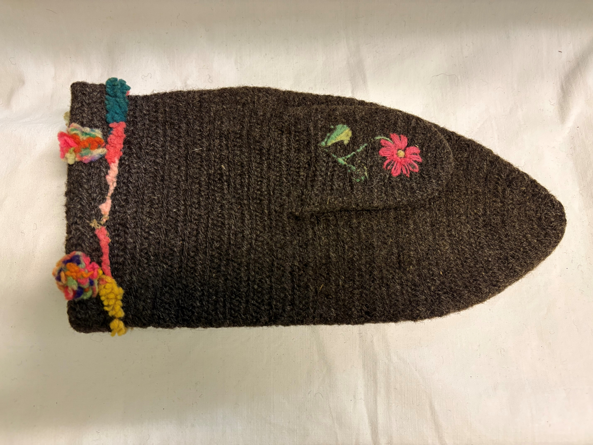 Brudgumsvantar, bruna. Broderade med yllegarn i färgerna lila, gult, grönt, vitt och blått i schattersöm och stjälksöm. Nedvikt kant.
